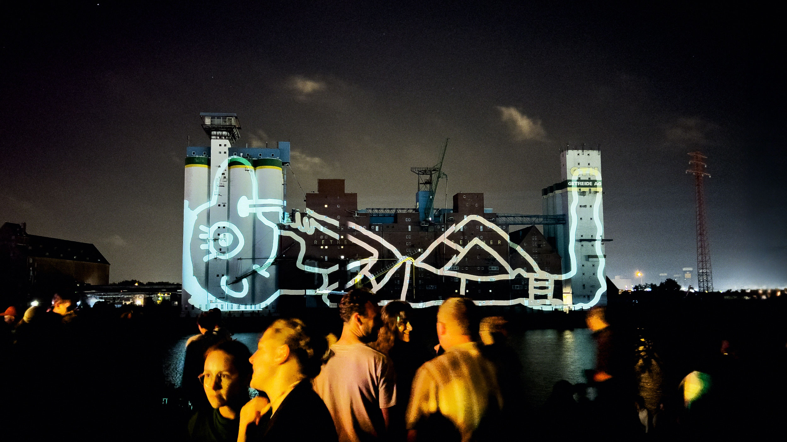 A large-scale projection depicting a reclining figure, intricately illustrated, while picking his nose